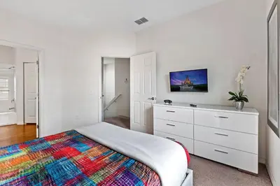 a white bedroom with a bed and a dresser at Casa 4Q West Lucaya – 5min da Disney in Kissimmee