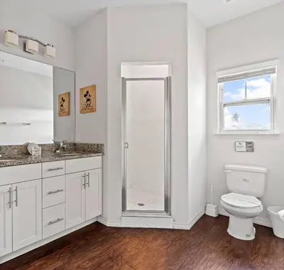 a white bathroom with a shower and a toilet at Casa 4Q West Lucaya – 5min da Disney in Kissimmee