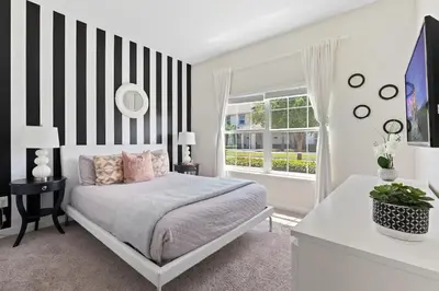 a bedroom with a bed with a black and white striped wall at Casa 5Q c/ Piscina Privativa - Storey Lake Resort in Kissimmee