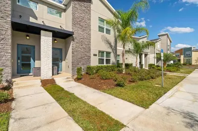 a house with palm trees in front of it at Villa 4Q c/ Piscina Priv. & Temática in Kissimmee