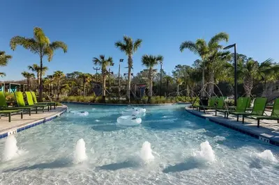 a pool at a resort with chairs and palm trees at Villa 4Q c/ Piscina Priv. & Temática in Kissimmee