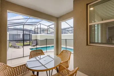 a dining room with a table and chairs and a large window at Casa 4Q com Piscina e Quartos Temáticos in Kissimmee