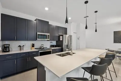 a kitchen with black cabinets and a white counter top at Casa 4Q com Piscina e Quartos Temáticos in Kissimmee