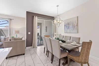 a dining room and living room with a table and chairs at Casa 4Q c/ Piscina Priv. no Storey Lake in Kissimmee