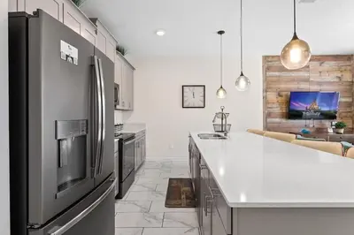 a kitchen with a stainless steel refrigerator and a counter at Casa 4Q c/ Piscina Priv. no Storey Lake in Kissimmee