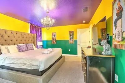 a bedroom with a bed and a colorful wall at Let's Glo Now Adventure Cove Villa townhouse in Kissimmee