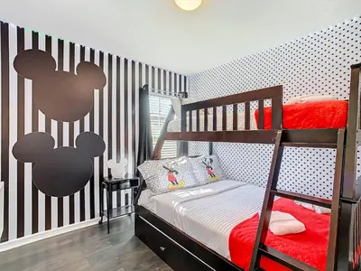a small bedroom with a bunk bed with red sheets at Cozy Townhouse with Private Pool in Kissimmee in Kissimmee