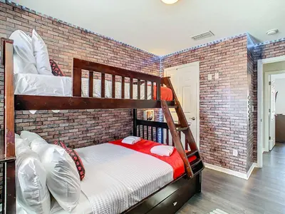 a bedroom with two bunk beds in a brick wall at Cozy Townhouse with Private Pool in Kissimmee in Kissimmee