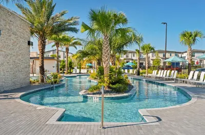 a swimming pool with palm trees in a resort at Brand NEW 5 BRD At Paradiso Grande Near Sea World in Orlando