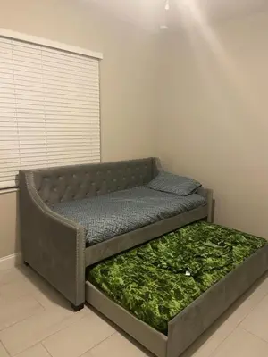a bed sitting in a room with a green mattress at Orlando 4 bedroom built in 2021 in Orlando