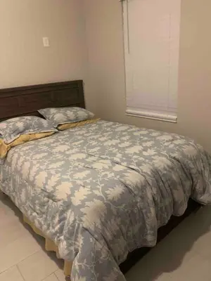 a bedroom with a bed with a comforter and a window at Orlando 4 bedroom built in 2021 in Orlando