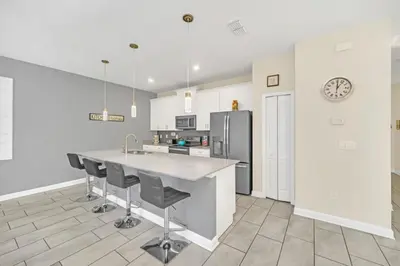 a kitchen with a counter and a refrigerator at Beautiful Paradise Palms Retreat townhouse in Kissimmee
