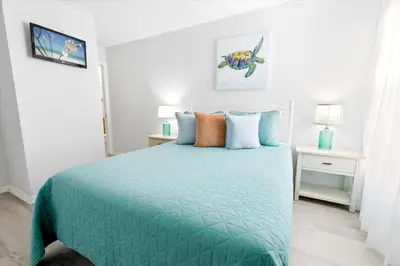 a bedroom with a bed with a blue comforter at Casa 5Q c/ Piscina Priv. e Sala de Jogos in Kissimmee