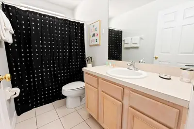 a bathroom with a toilet and a shower curtain at Casa 5Q c/ Piscina Priv. e Sala de Jogos in Kissimmee