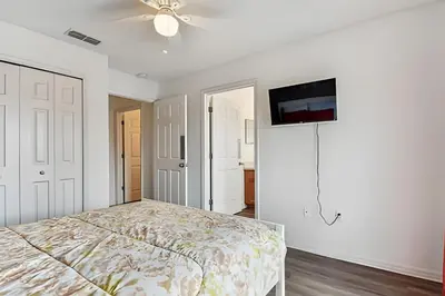 a bedroom with a bed and a ceiling fan at Casa Aconchegante no Lake Berkley – Perto da Disney in Kissimmee
