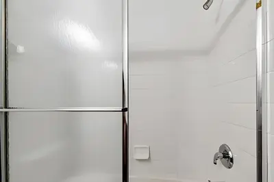 a shower in a bathroom with a glass door at Casa Aconchegante no Lake Berkley – Perto da Disney in Kissimmee