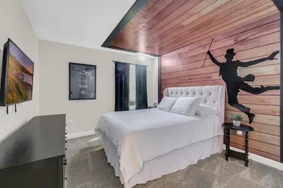 a bedroom with a bed with a painting on the wall at 6 Bedrooms 6 Bathrooms Storey Lake home in Orlando