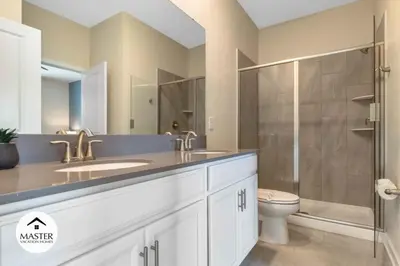 a bathroom with a sink and a shower and a toilet at 9 Bedrooms 5 Bathrooms Storey Lake home in Kissimmee