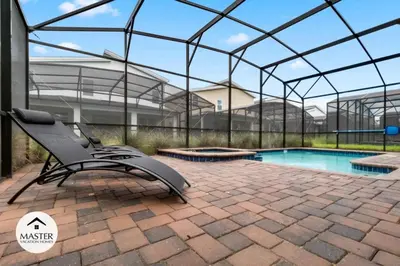 a swimming pool with a chair in a glass house at 9 Bedrooms 5 Bathrooms Storey Lake home in Kissimmee