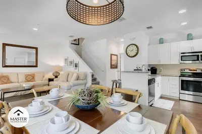 a kitchen and a living room with a table and chairs at 4 Bedroom 3 Bathroom Lucaya Village townhouse in Kissimmee