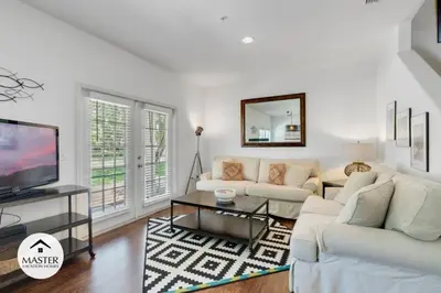 a living room with white furniture and a flat screen tv at 4 Bedroom 3 Bathroom Lucaya Village townhouse in Kissimmee