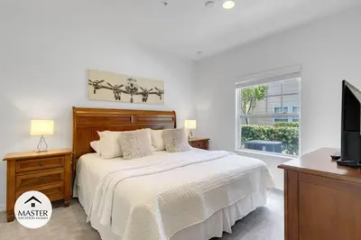 a white bedroom with a bed and a window at 4 Bedroom 3 Bathroom Lucaya Village townhouse in Kissimmee