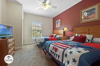 a bedroom with two beds and a flat screen tv at 3 Bedrooms 2 Bathrooms Lucaya Village townhouse in Kissimmee