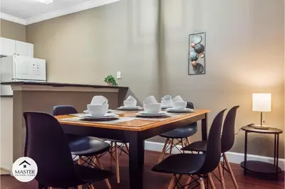 a dining room table with chairs and a table with dishes on it at 3 Bedrooms 2 Bathrooms Lucaya Village townhouse in Kissimmee