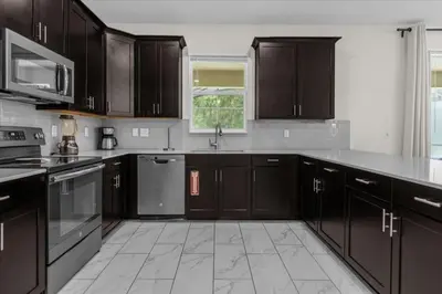 a kitchen with dark brown cabinets and a sink at 7 Bedroom 6 Bathrooms Storey Lake Resort home in Kissimmee