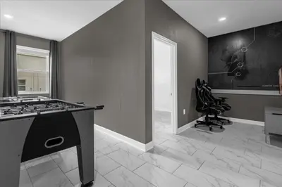 a kitchen with a stove and a chair in a room at 7 Bedroom 6 Bathrooms Storey Lake Resort home in Kissimmee