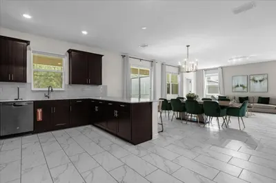 a kitchen and dining room with a table and chairs at 7 Bedroom 6 Bathrooms Storey Lake Resort home in Kissimmee