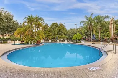 a swimming pool in a park with trees at 3 Bedrooms 2 Bathrooms Lucaya Village townhouse in Kissimmee