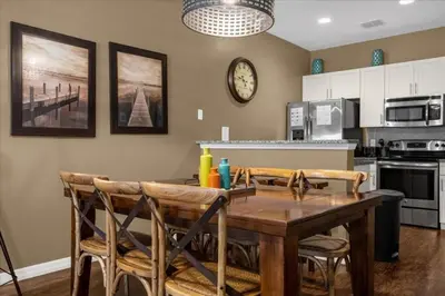 a kitchen with a table and chairs and a clock on the wall at 3 Bedrooms 2 Bathrooms Lucaya Village townhouse in Kissimmee