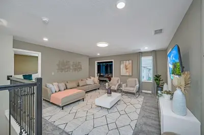 a living room with a couch and a table at 9 bedrooms 5 Bathrooms Storey Lake Game Room Too home in Kissimmee