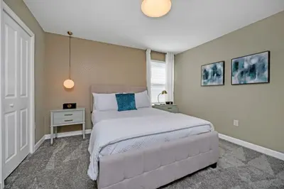 a bedroom with a large bed with a blue pillow at 9 bedrooms 5 Bathrooms Storey Lake Game Room Too home in Kissimmee