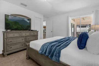 a bedroom with a bed and a television on a dresser at 3 Bedrooms 2 Bathrooms Lake Berkley home in Kissimmee