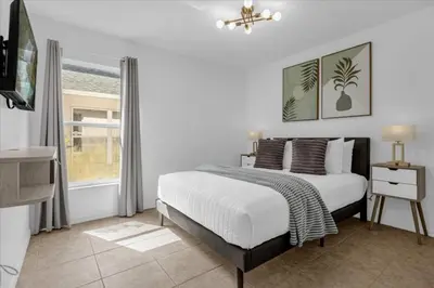 a white bedroom with a bed and a window at 3 Bedrooms 2 Bathrooms Lake Berkley home in Kissimmee