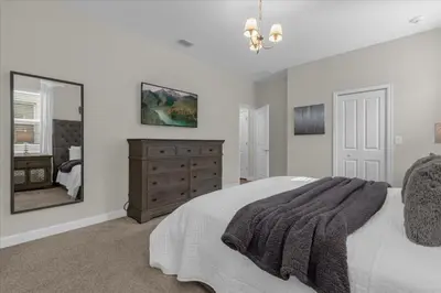 a bedroom with a bed and a dresser and a mirror at 9 Bed Storey Lake Star Wars Dream Home home in Kissimmee