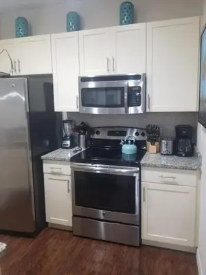 a kitchen with a stainless steel stove and microwave at 3 Bed 2 Bath Condo in Lucaya Village Near Disney townhouse in Kissimmee