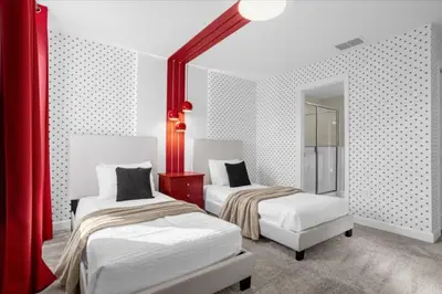 two beds in a room with red and white walls at 9 bed Home Storey Lake home in Kissimmee