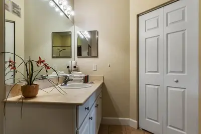 a bathroom with a sink and a mirror at 4 Bedrooms 3 Bathrooms Lucaya Village townhouse in Kissimmee