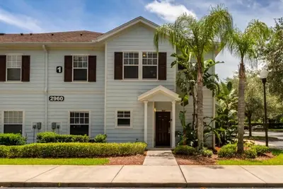 a house with palm trees in front of it at 4 Bedrooms 3 Bathrooms Lucaya Village townhouse in Kissimmee