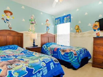 a bedroom with two beds and a wall with cartoons at Southern Comfort Private Pool Spa Near Disney! villa in Kissimmee