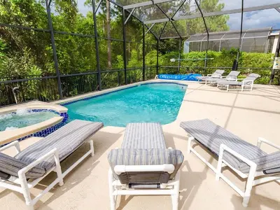 a pool with chaise lounge chairs and a swimming pool at Southern Comfort Private Pool Spa Near Disney! villa in Kissimmee