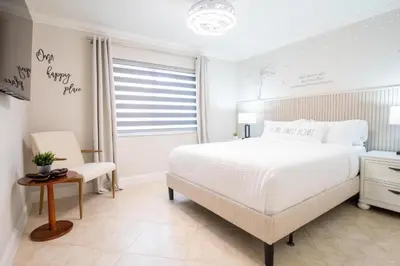 a white bedroom with a large bed and a window at Longwood Private Suite - Near Orlando - Modern, Private Entrance, Fast WiFi in Orlando
