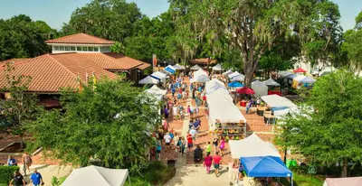a crowd of people walking around a market with umbrellas at Modern 3BR Resort Condo with Pool near Disney in Orlando