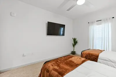 a bedroom with two beds and a flat screen tv at Magical Retreat Outside of Disney in Orlando