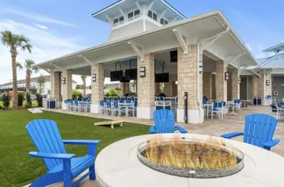 a patio with blue chairs and a fountain in front of a building at New 2025 Bambi Orlando Pool Vacation Home in Clermont