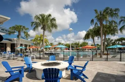 a patio with blue chairs and a table and a pool at New 2025 Bambi Orlando Pool Vacation Home in Clermont