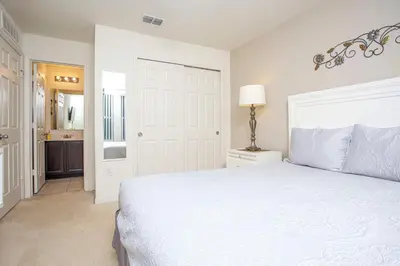 a white bedroom with a bed and a bathroom at Family Friendly 4 Bedrooms with GameRoom close to Disney in Compass Bay 5103 in Kissimmee